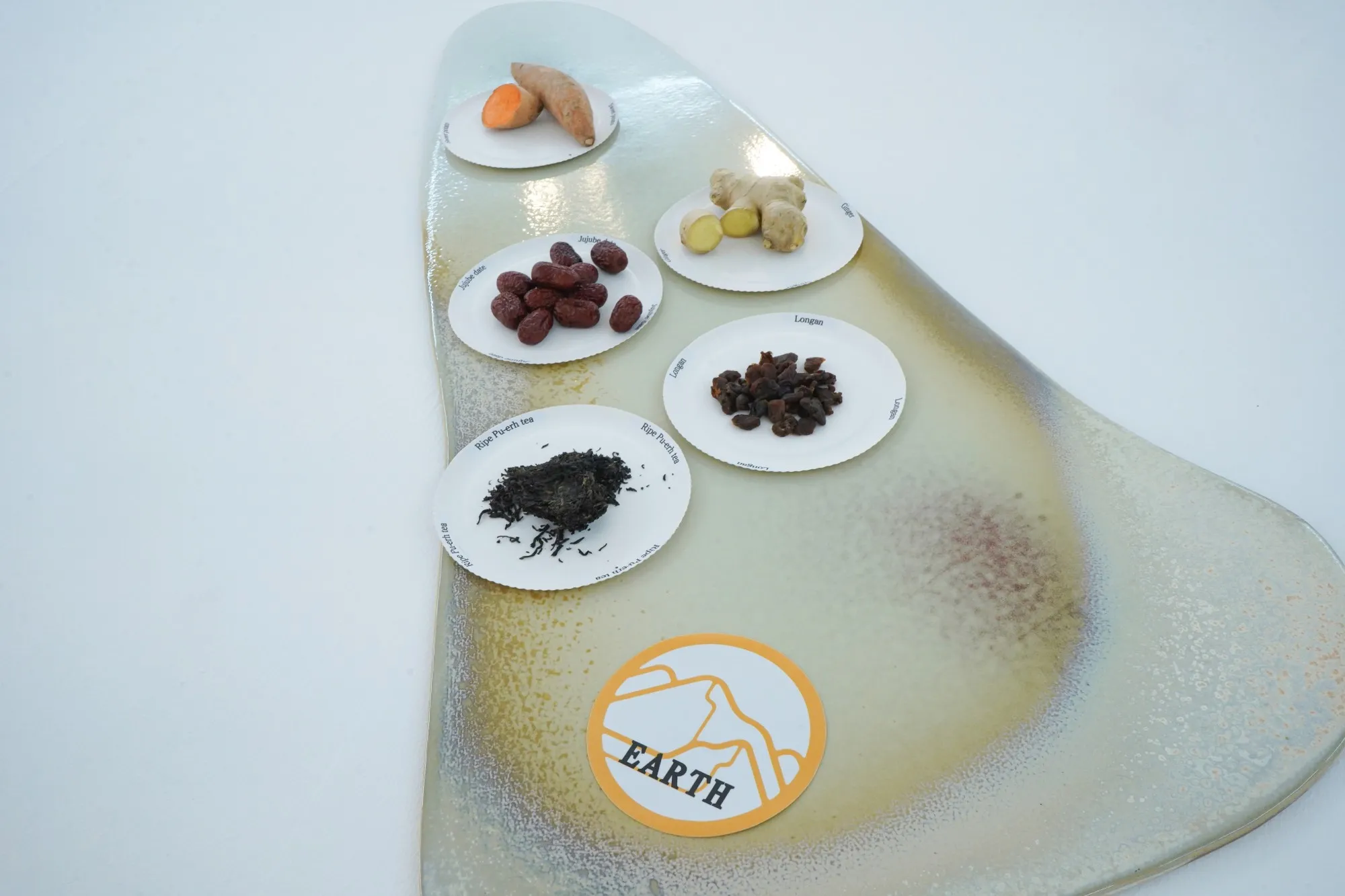 Bord van het element Aarde met zoete aardappel, gember, jujube dadels, longan en rijpe pu-erh thee